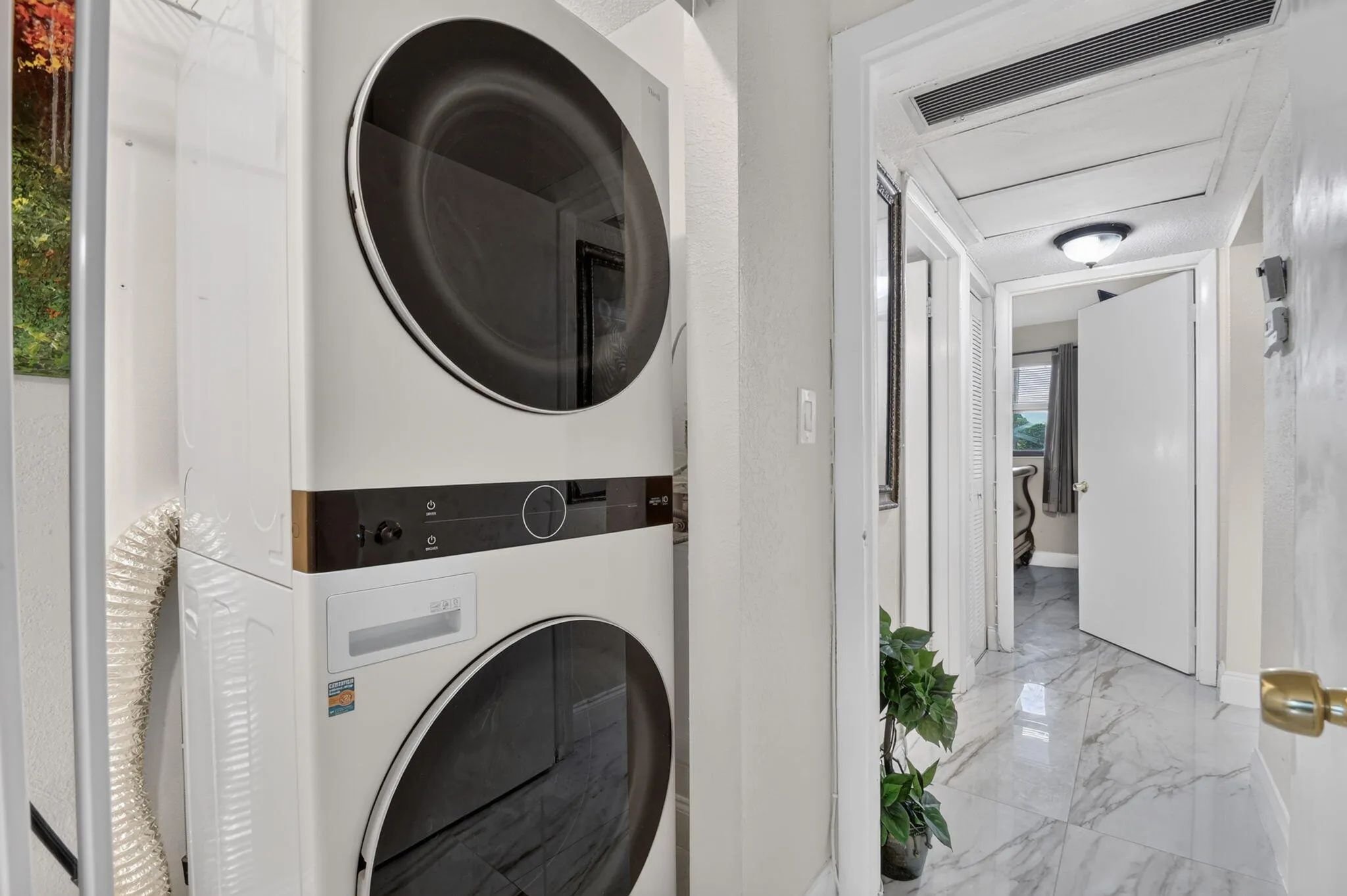 Stackable white washer and dryer unit, featuring a contemporary design