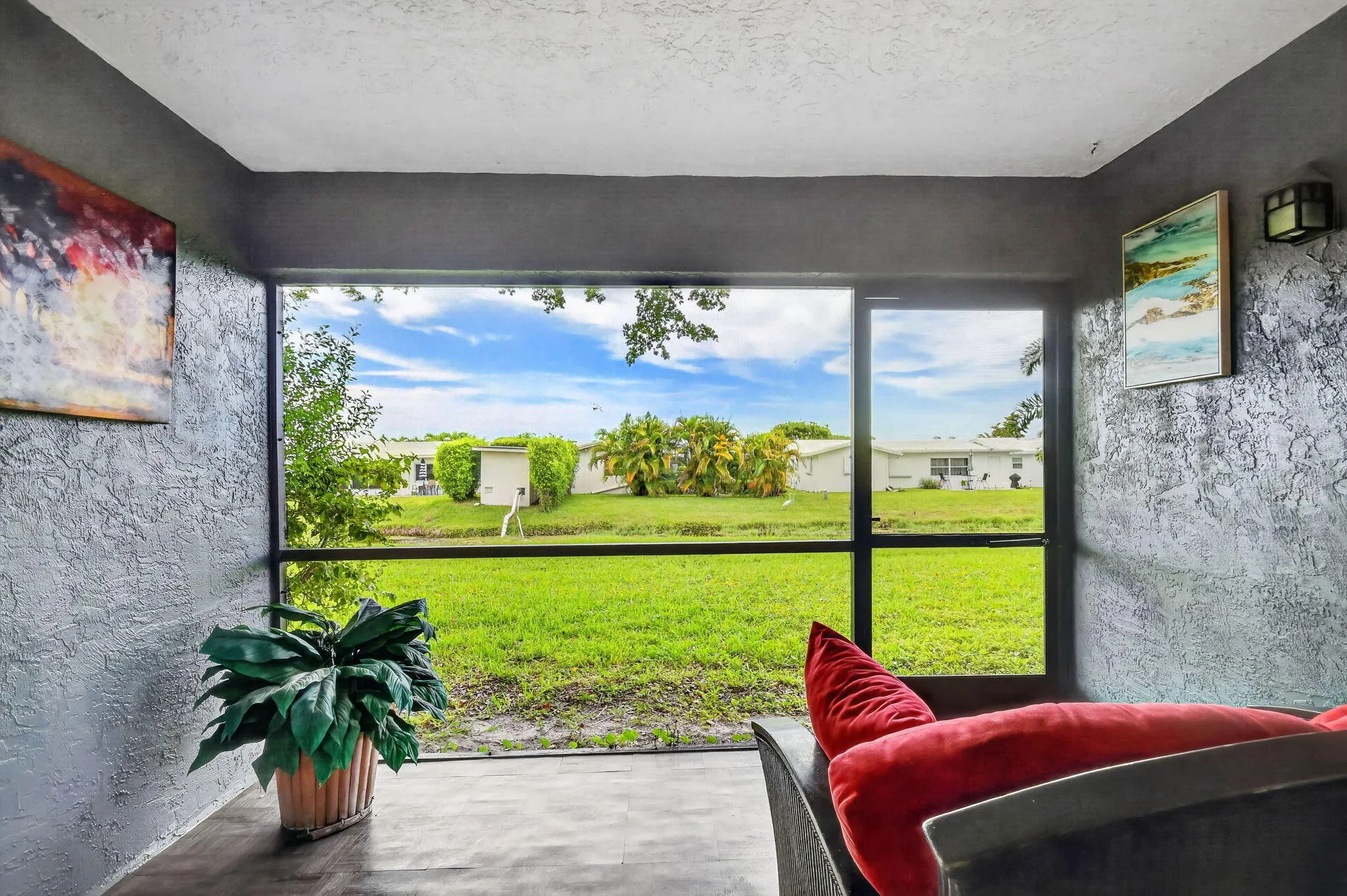 Large screened windows frame a broad expanse of lush green landscape