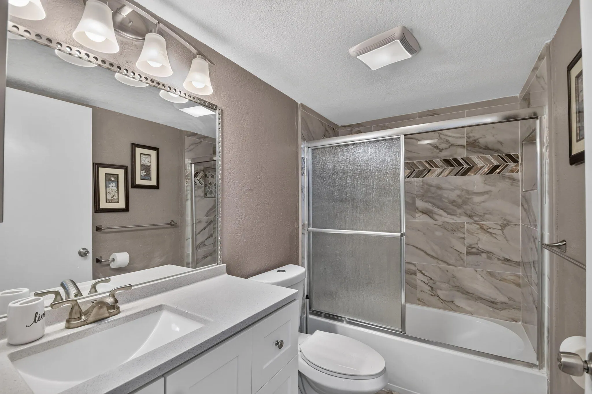 Bathroom featuring a white vanity with a light countertop, a built-in sink, and brushed nickel fixtures