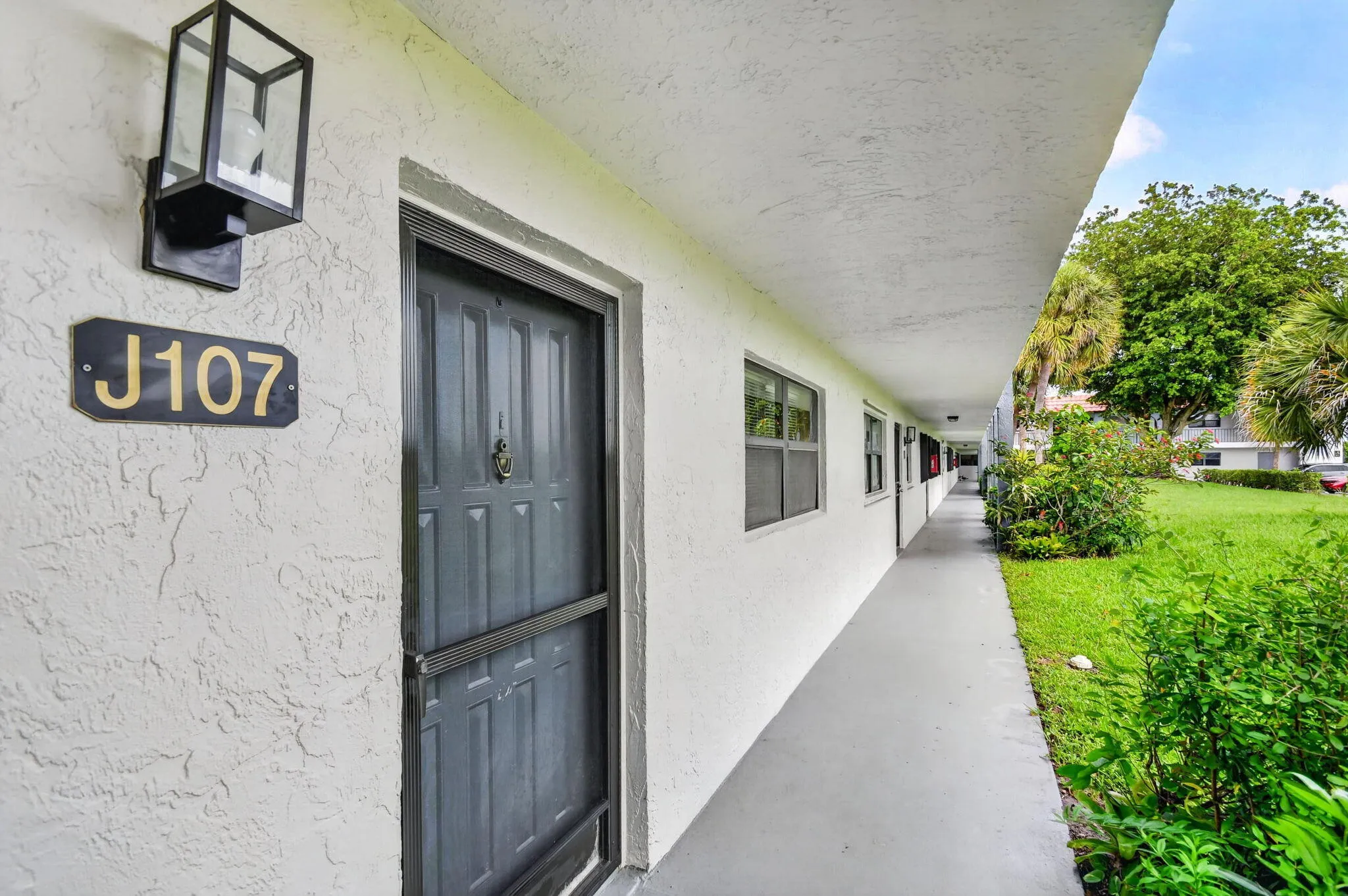 Exterior entryway featuring stucco siding and a black front door with an integrated screen door