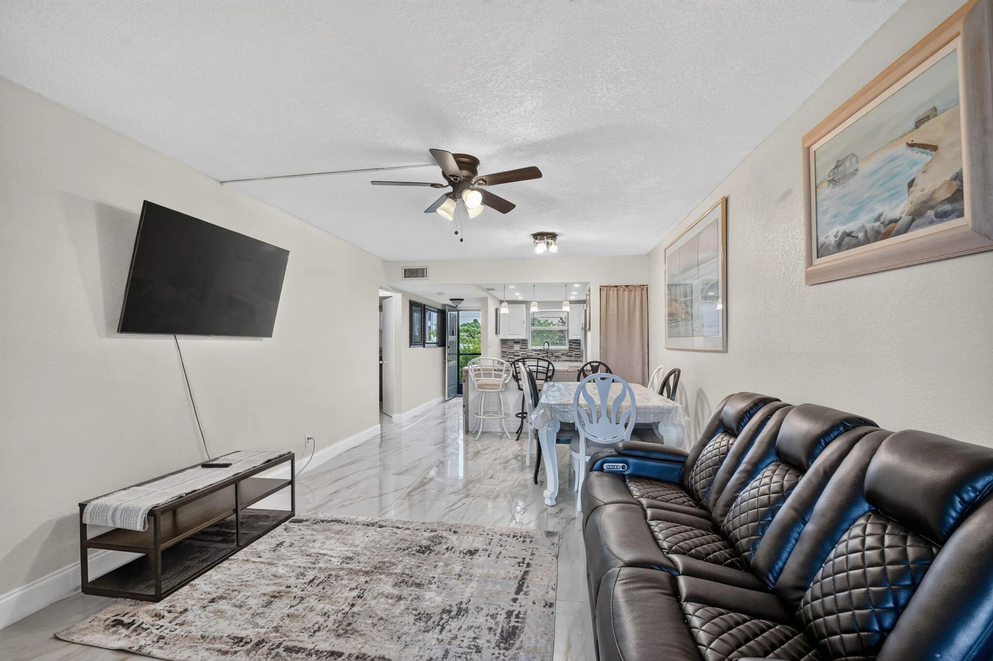 Open-concept living space featuring wood-finish flooring, a ceiling fan, and recessed lighting