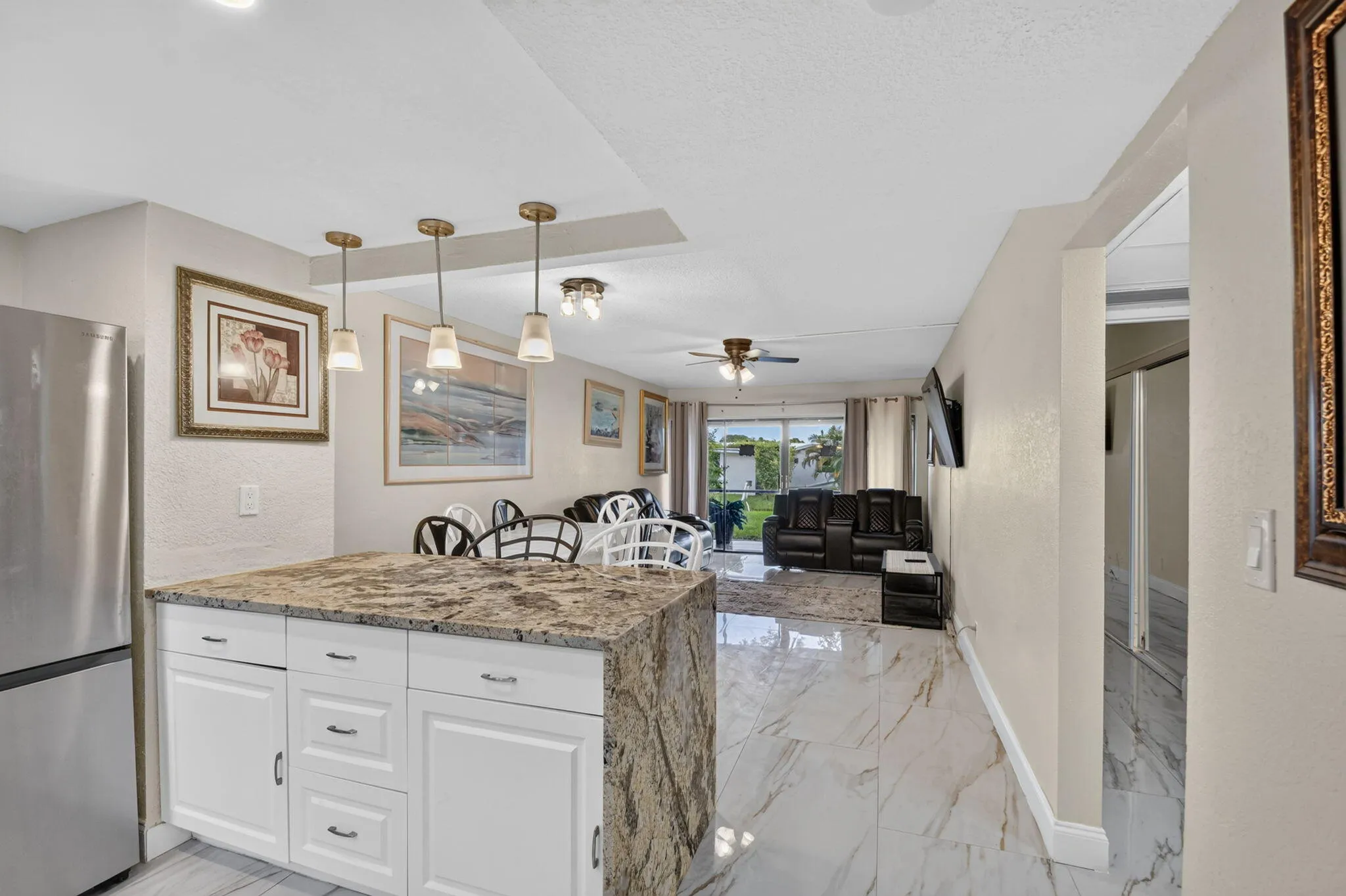 Kitchen island featuring a stone countertop and white shaker-style cabinetry