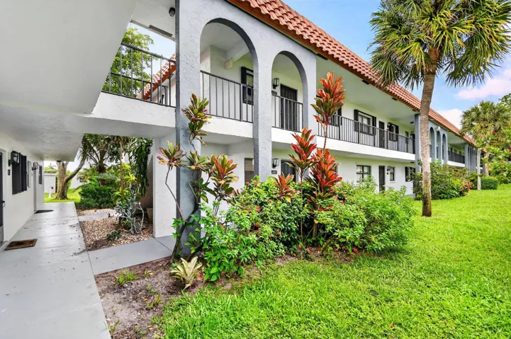 Spanish-style residential building featuring a terracotta tile roof and stucco exterior