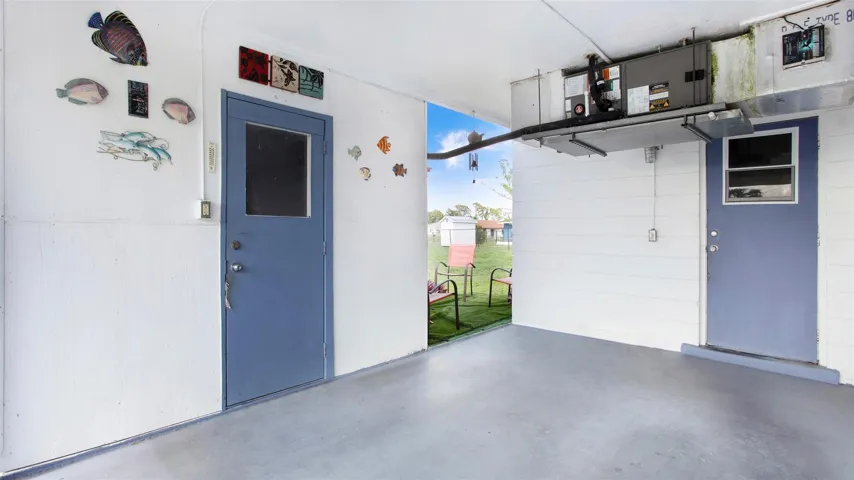 storage room off carport door leading to laundry room