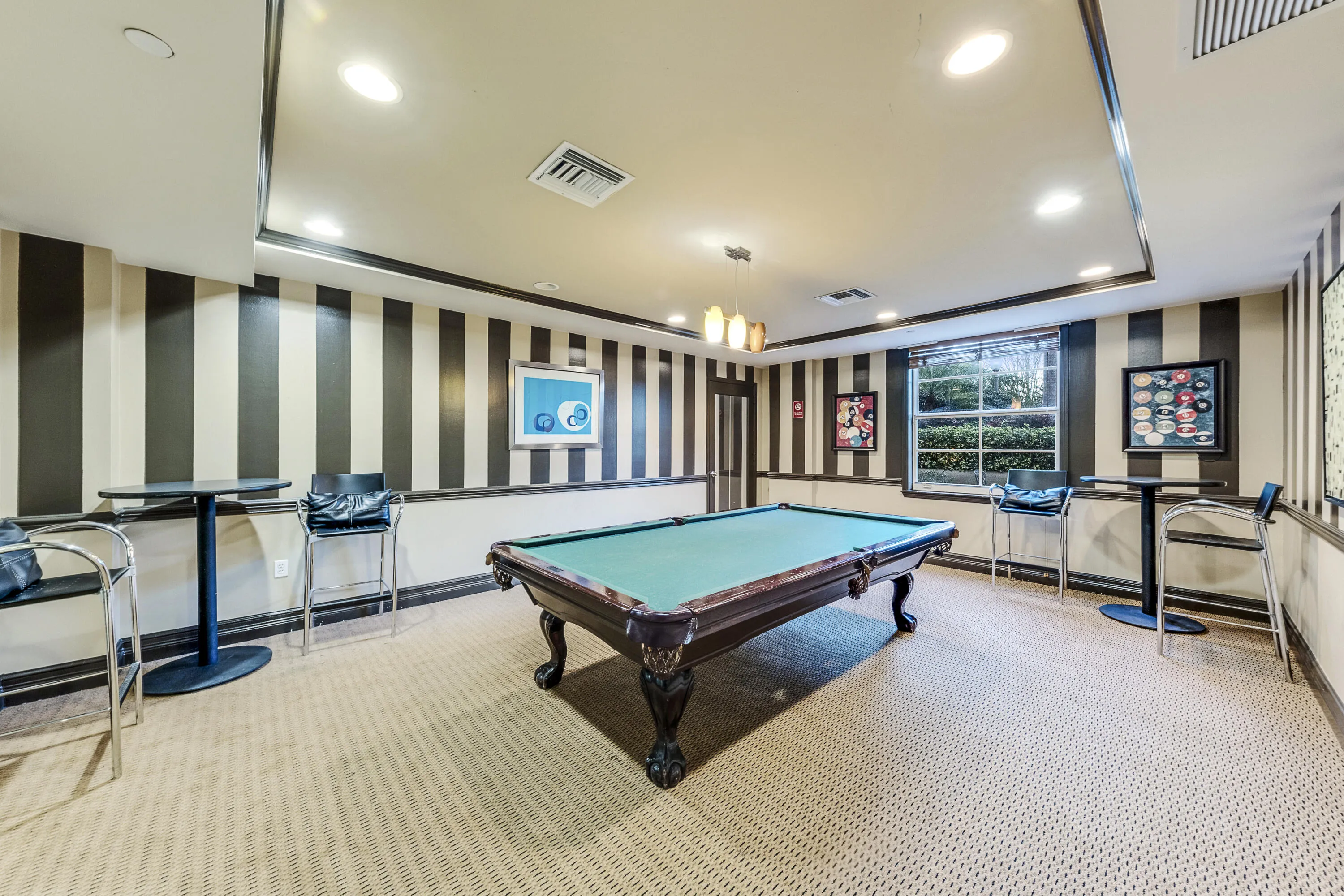 Resident game room featuring a billiards table, darts, and space to relax with friends and neighbors.