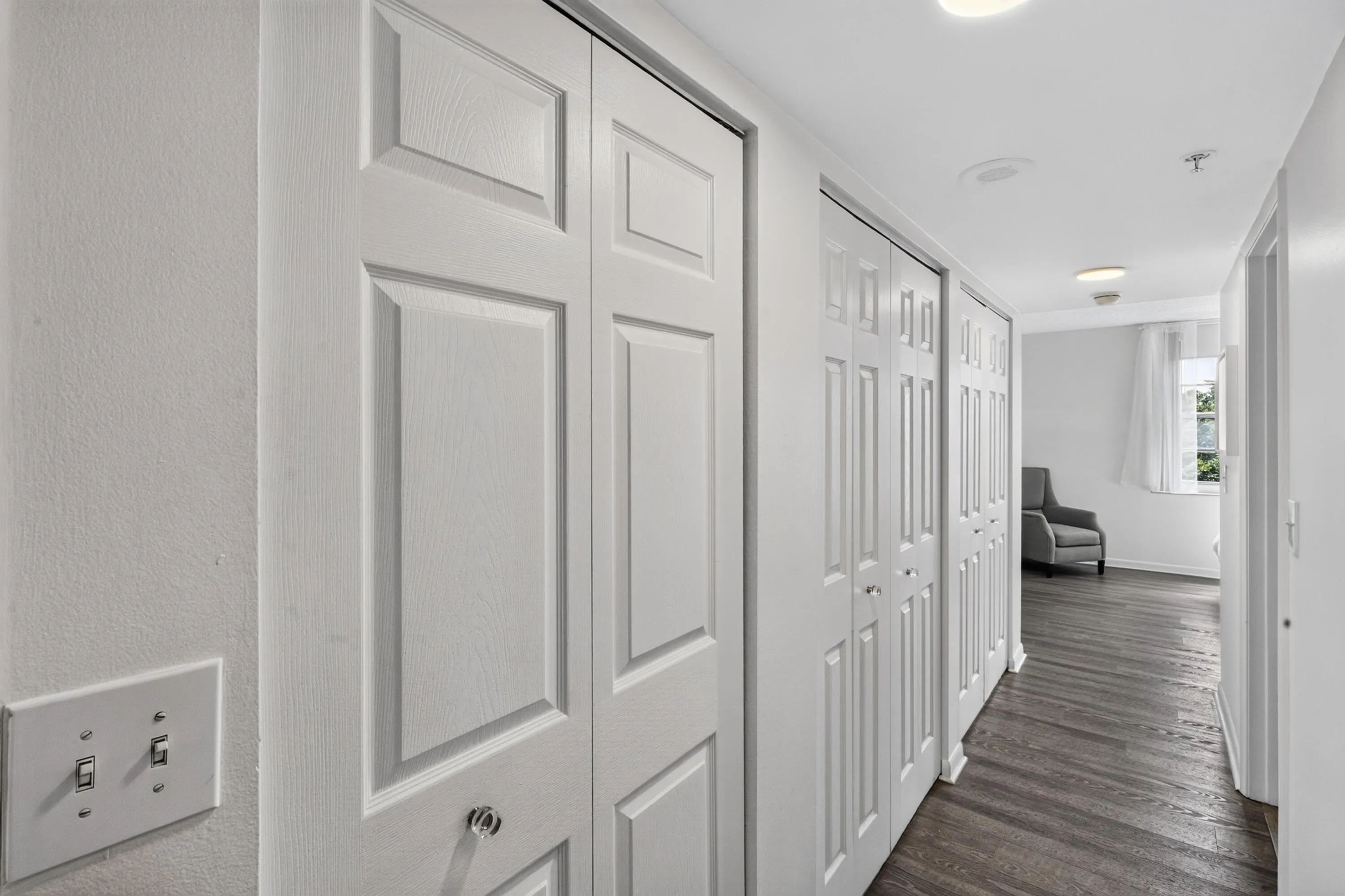 Hallway to primary with multiple closets, built-in linen storage, and abundant storage space help keep everything organized.
