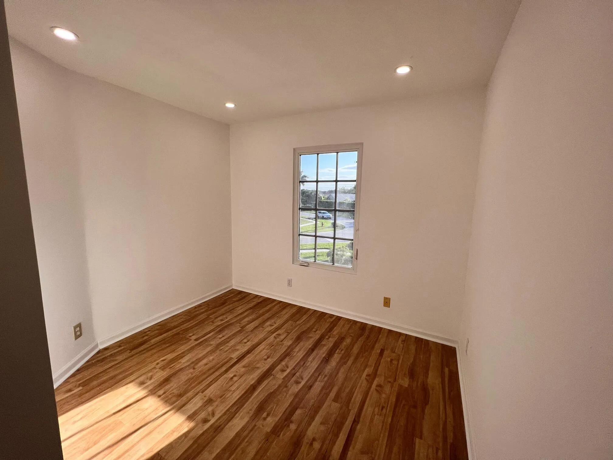 Crisp white walls frame a room featuring wood-finish flooring
