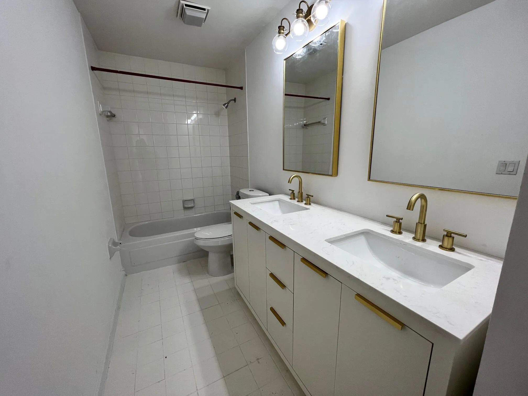 Dual vanity with integrated sinks and gold-finish hardware