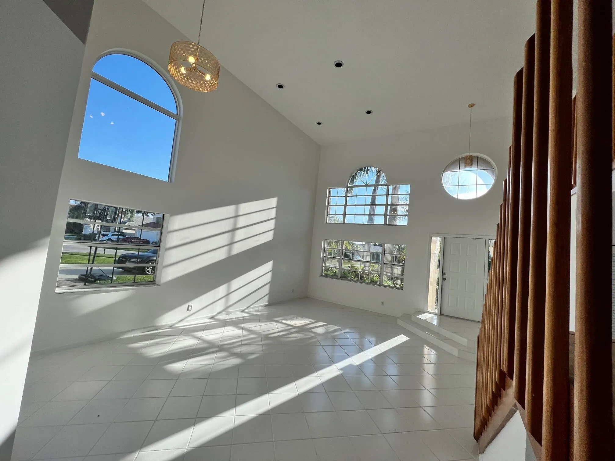 Vaulted ceiling entry foyer with white tile flooring