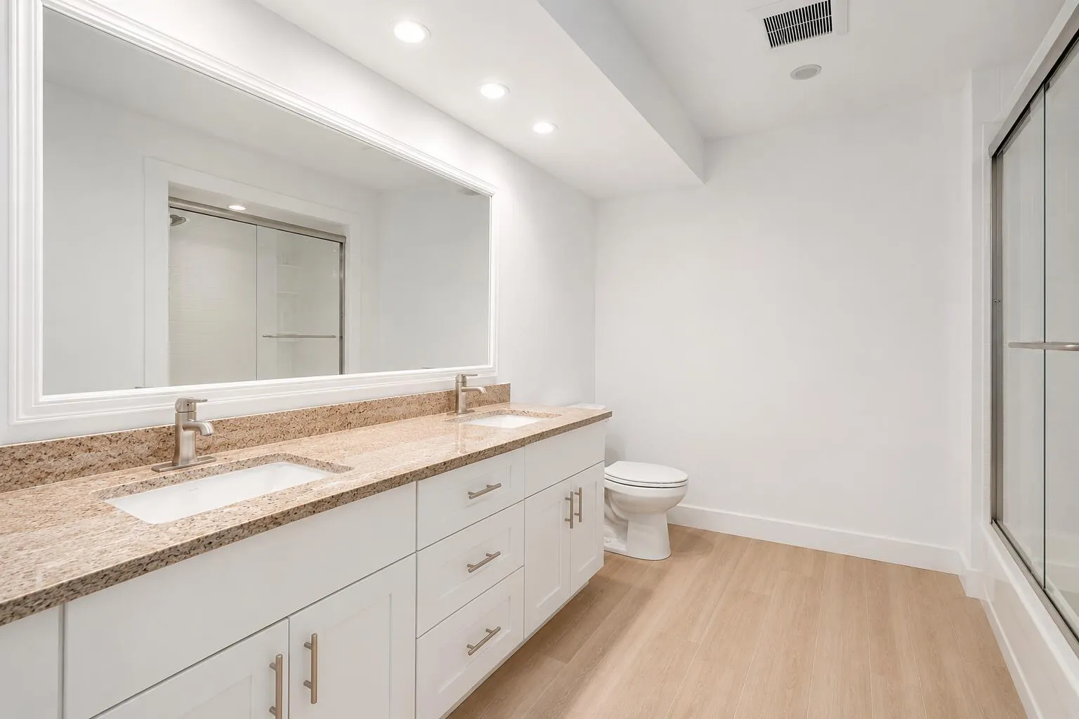 Dual vanity featuring undermount sinks and a speckled countertop