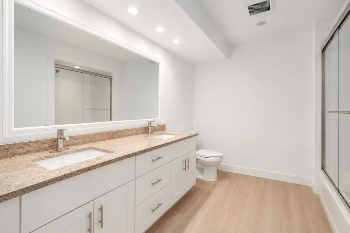 Dual vanity featuring undermount sinks and a speckled countertop