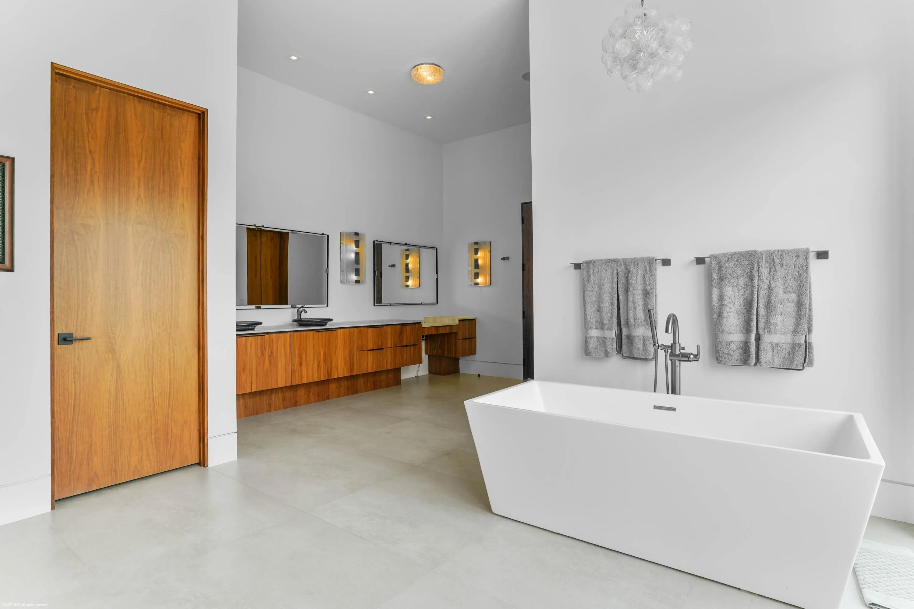 Soaking tub in the primary bath room with dual sink vanity.