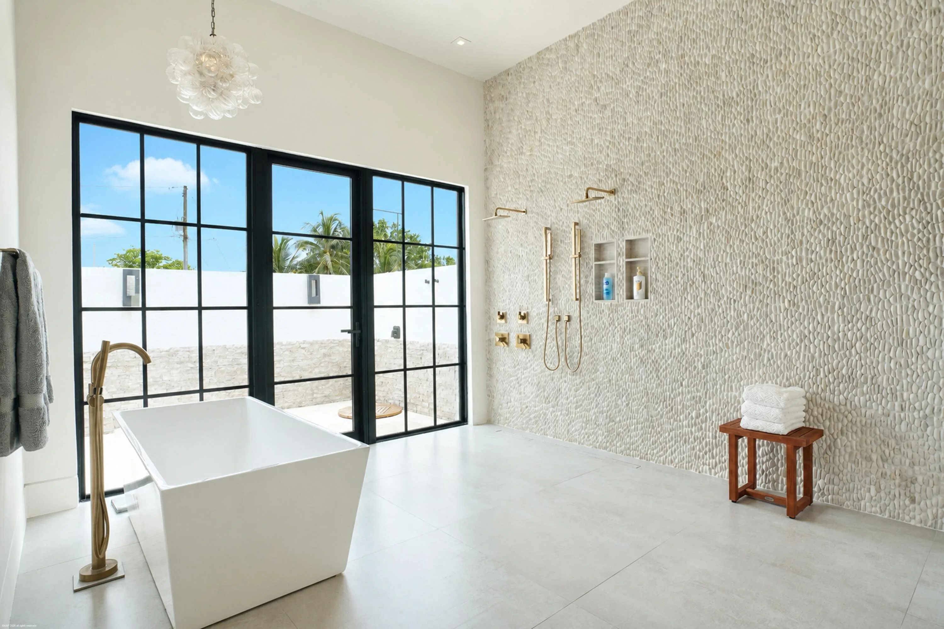 Wet room bathing area in the primary bathroom with outdoor showering courtyard beyond.