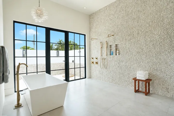 Wet room bathing area in the primary bathroom with outdoor showering courtyard beyond.