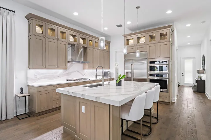 Perfect Chefs Kitchen Including Upper Wood Glass Cabinetry with Lighting, Cambria Quartz Countertops & Backsplash, Large Island with Cabinetry, Stainless Steel Appliances Including Outdoor Vented Hood & Custom Refrigerator Built In, 3 Over the Counter Drop Down Lighting, Undermount Cabinet Lighting & Walk In Pantry.