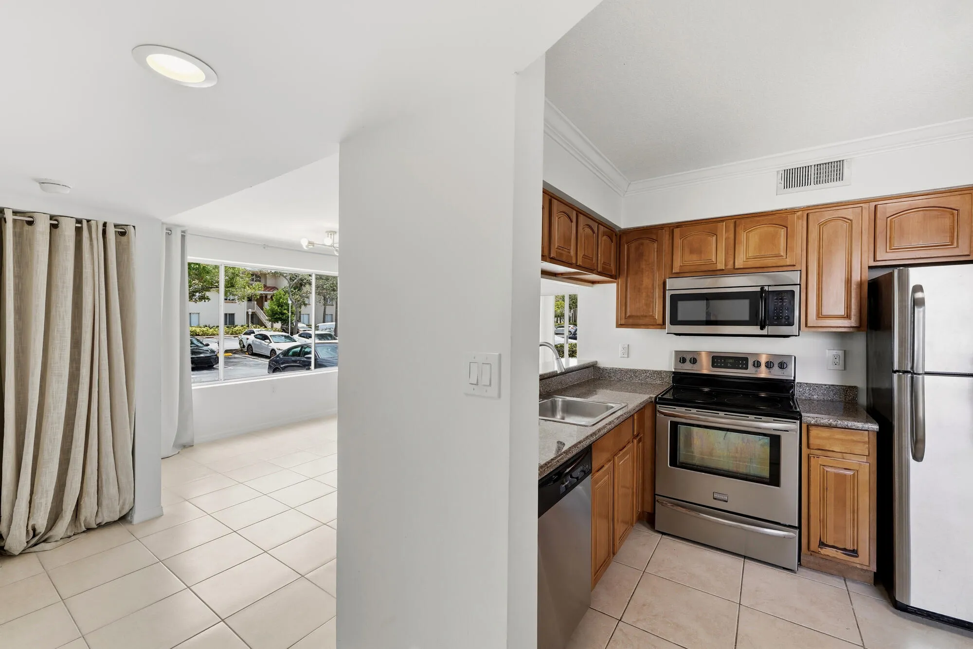 Kitchen featuring wood cabinetry, stainless steel appliances, and granite countertops