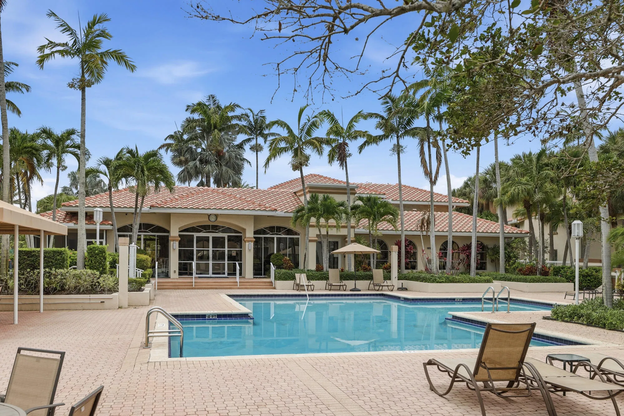Outdoor swimming pool with integrated spa, surrounded by a paver deck