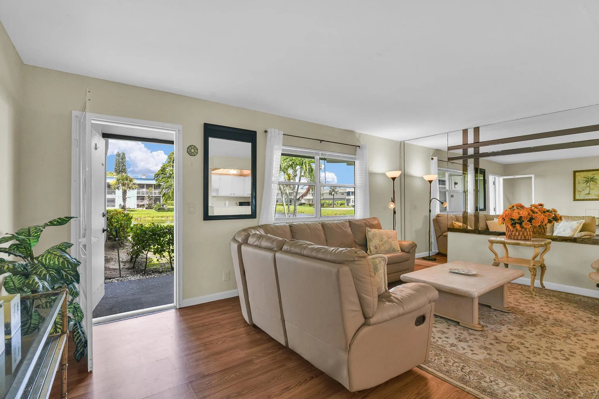Living area with wood-finish flooring, light neutral wall paint, and multiple windows
