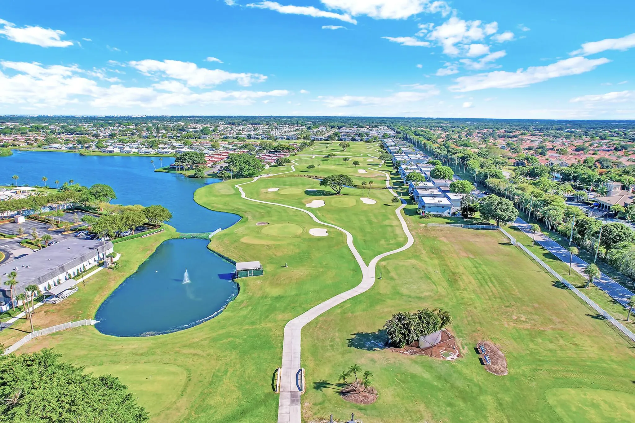 Expansive golf course and lake frontage featuring multiple greens, fairway, and water features with a central fountain