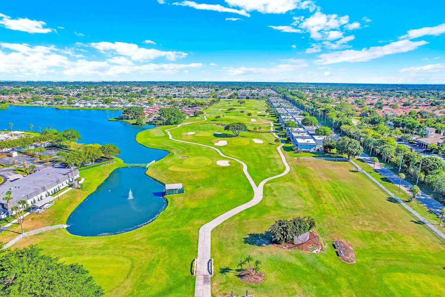 Expansive golf course and lake frontage featuring multiple greens, fairway, and water features with a central fountain