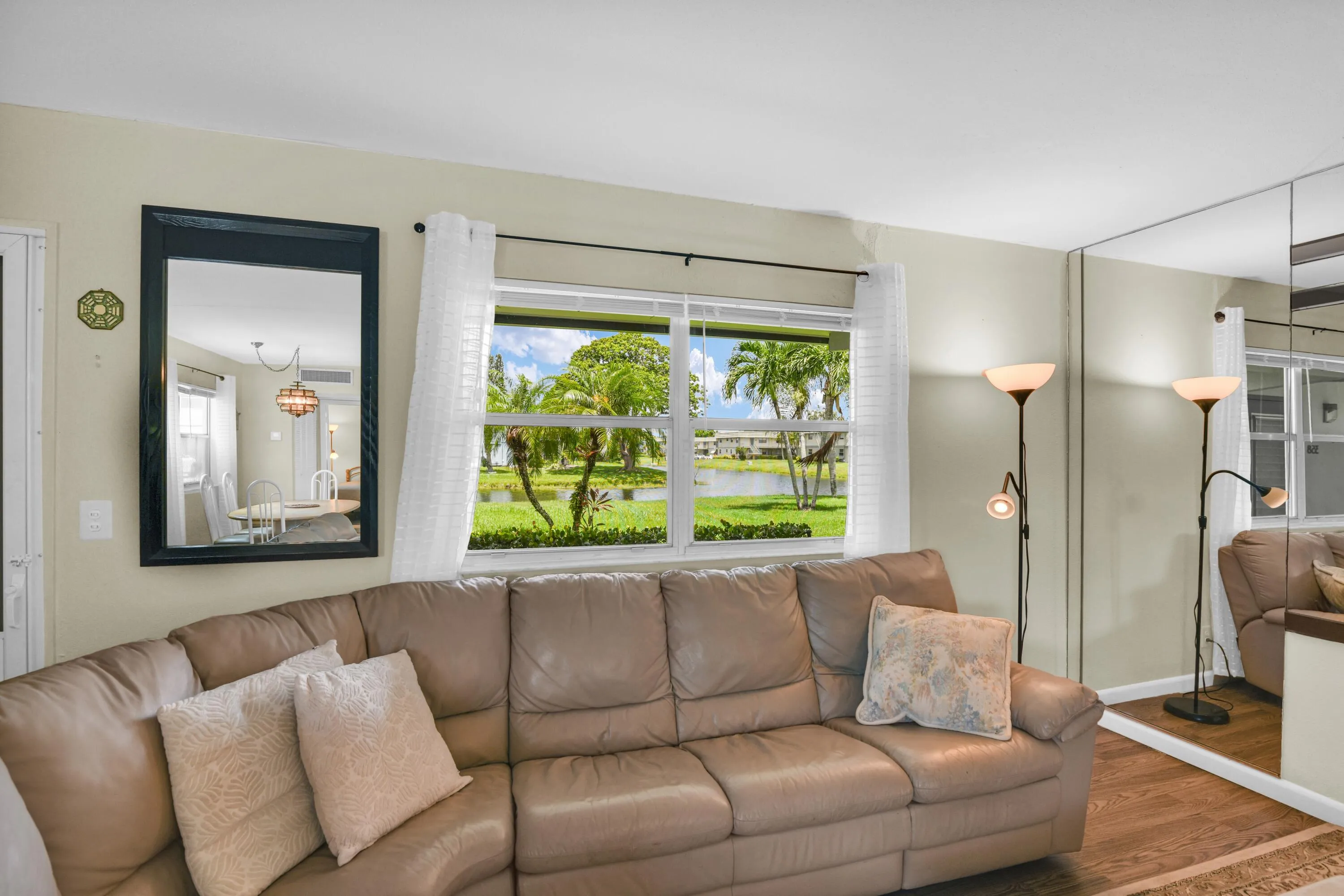 Expansive window offering views of the surrounding palm trees and water feature