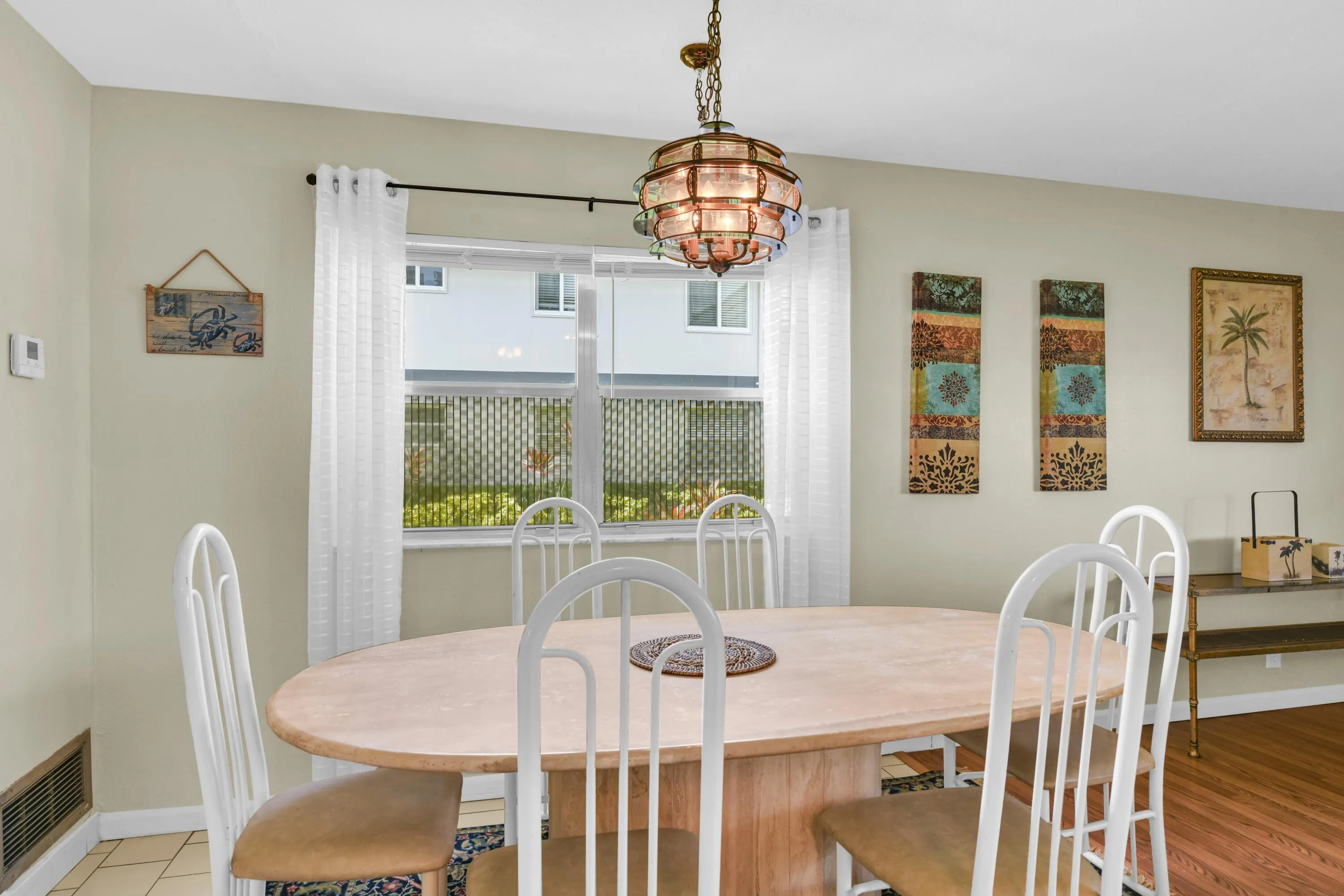 Dining area with a single-pane window, suspended stained glass chandelier, and ceramic tile flooring