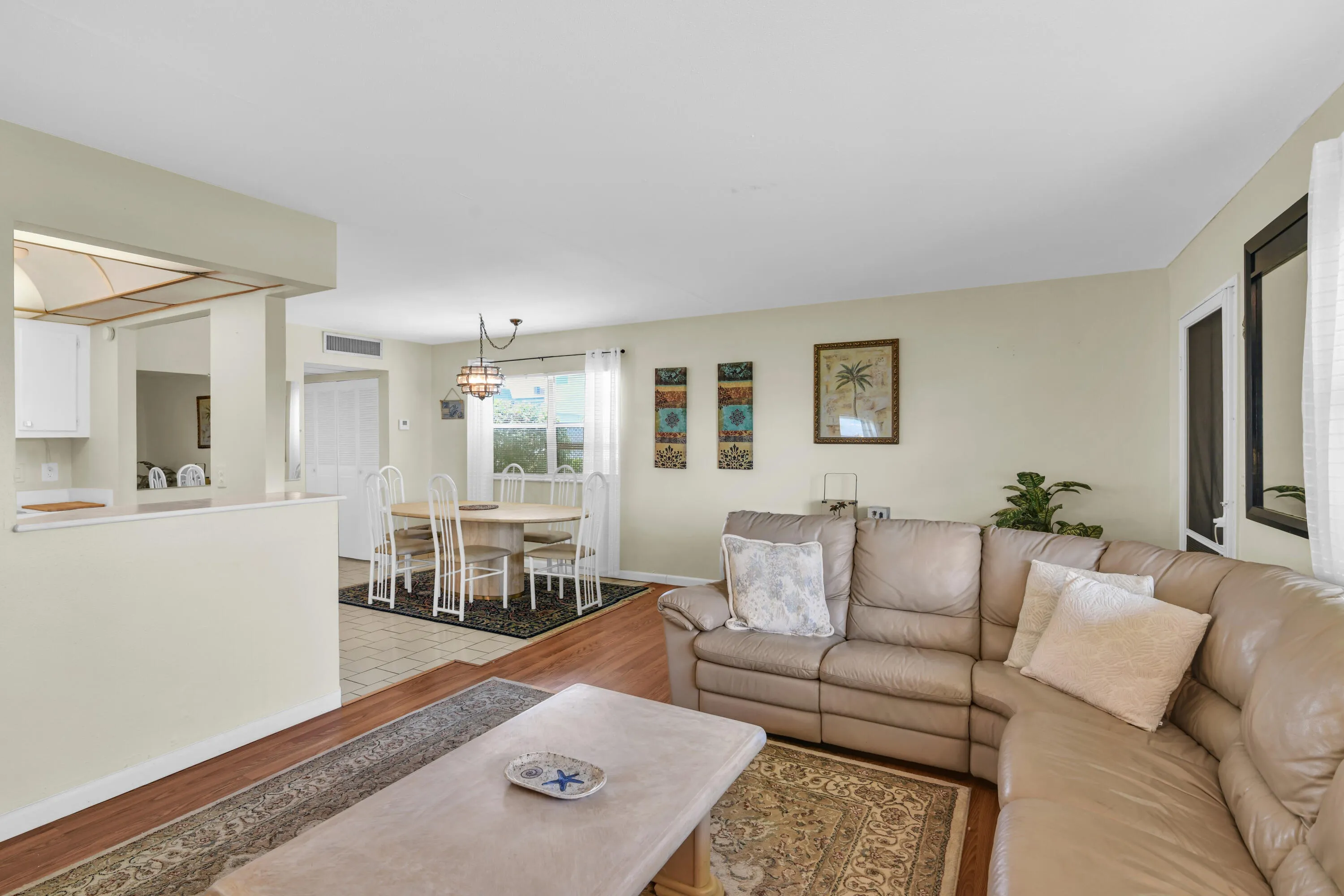 Open-concept living area featuring wood-finish flooring, light neutral wall tones, and recessed lighting