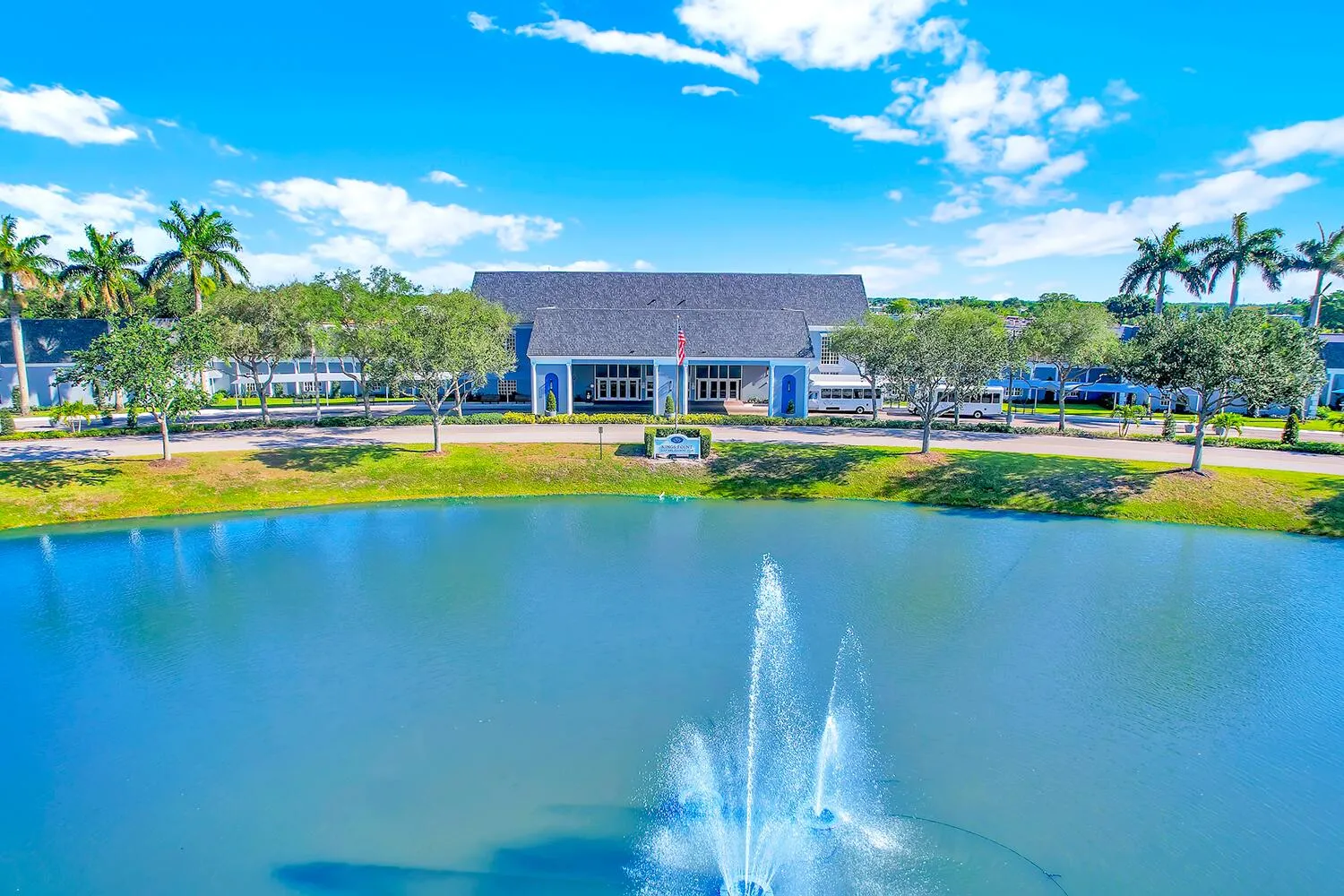 Manicured grounds featuring a prominent water body with a fountain
