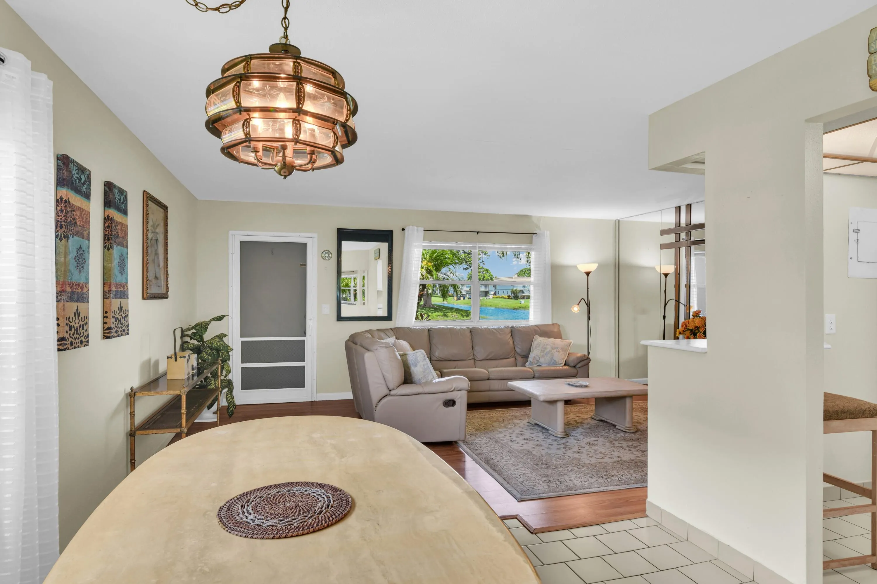 Expansive window offering views of the surrounding palm trees and water feature