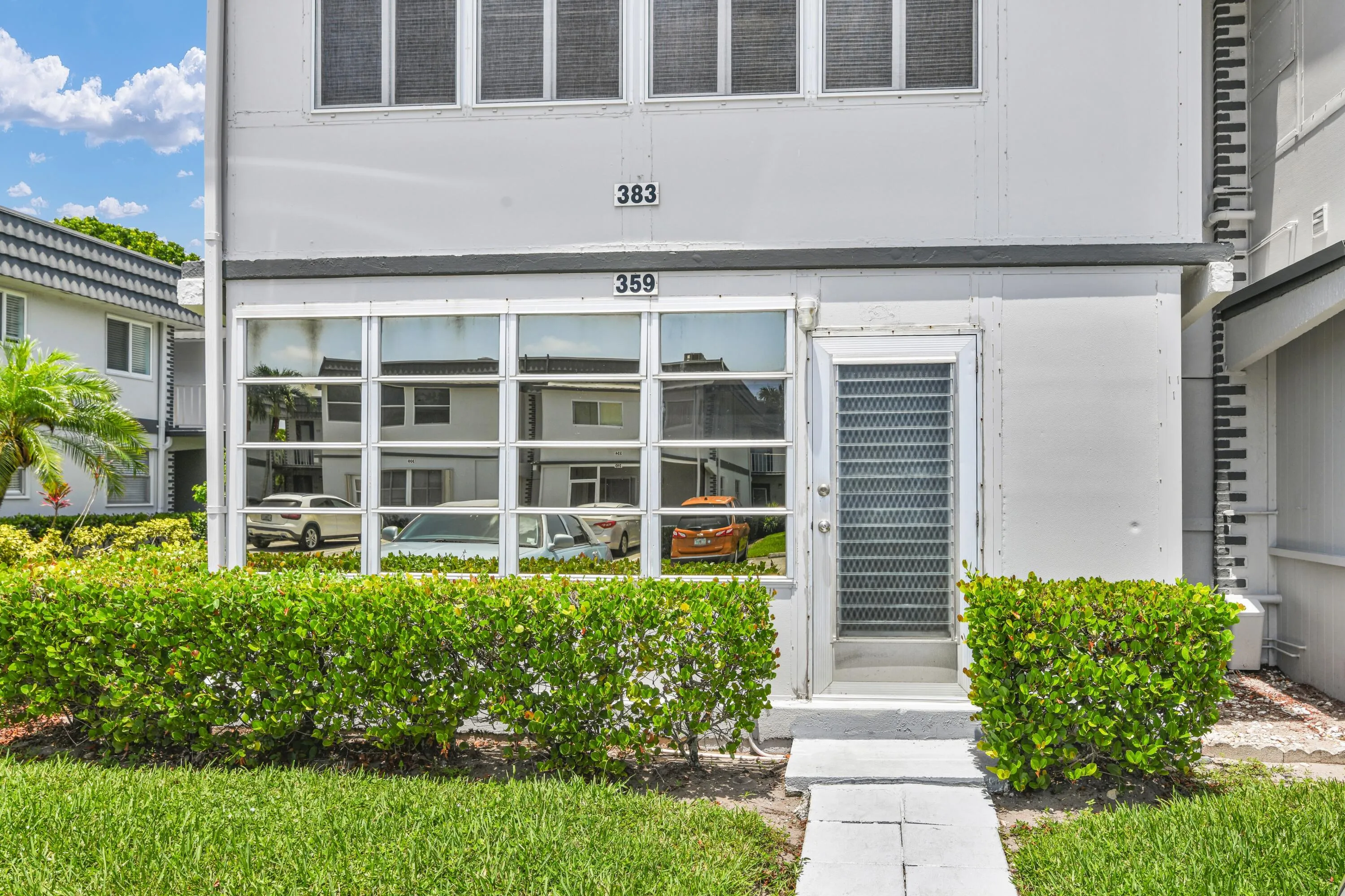 First-floor entry with a screened door and an exterior lighting fixture