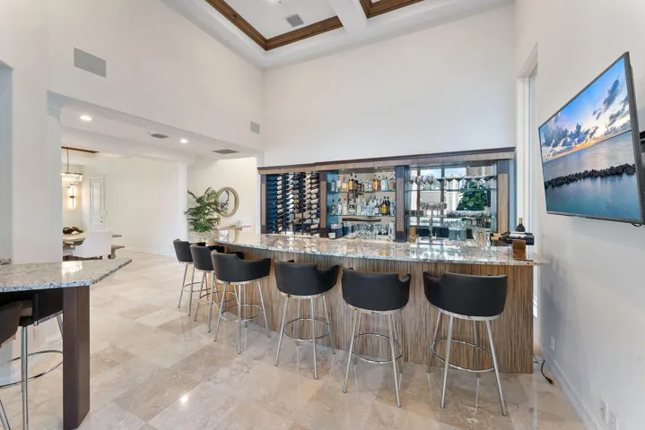 Custom built bar with sink, ice maker, refrigerator, and wine refrigerator.