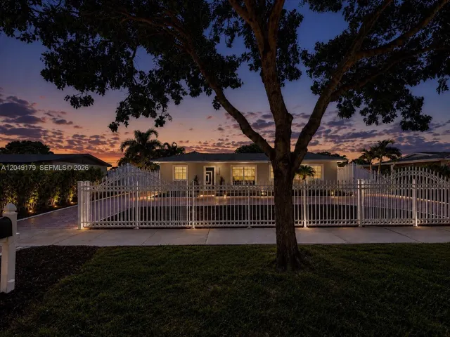 A must-see! Breathtaking twilight curb appeal welcomes you to this private 7,875 sq. ft. homesite featuring a grand motorized gated entrance, expansive stamped concrete circular driveway with additional parking, lush Podocarpus privacy landscaping, impact-rated front door, hurricane shutters, newer August 2023 roof, and beautifully illuminated grounds that create an unforgettable first impression.