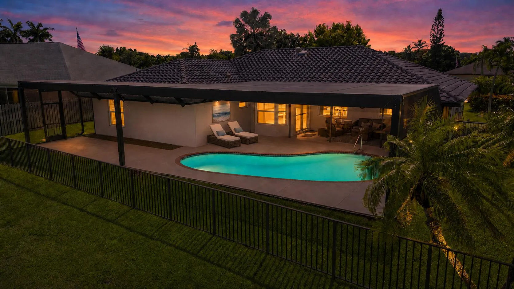 Curved swimming pool with an expansive concrete patio and covered lanai featuring recessed lighting