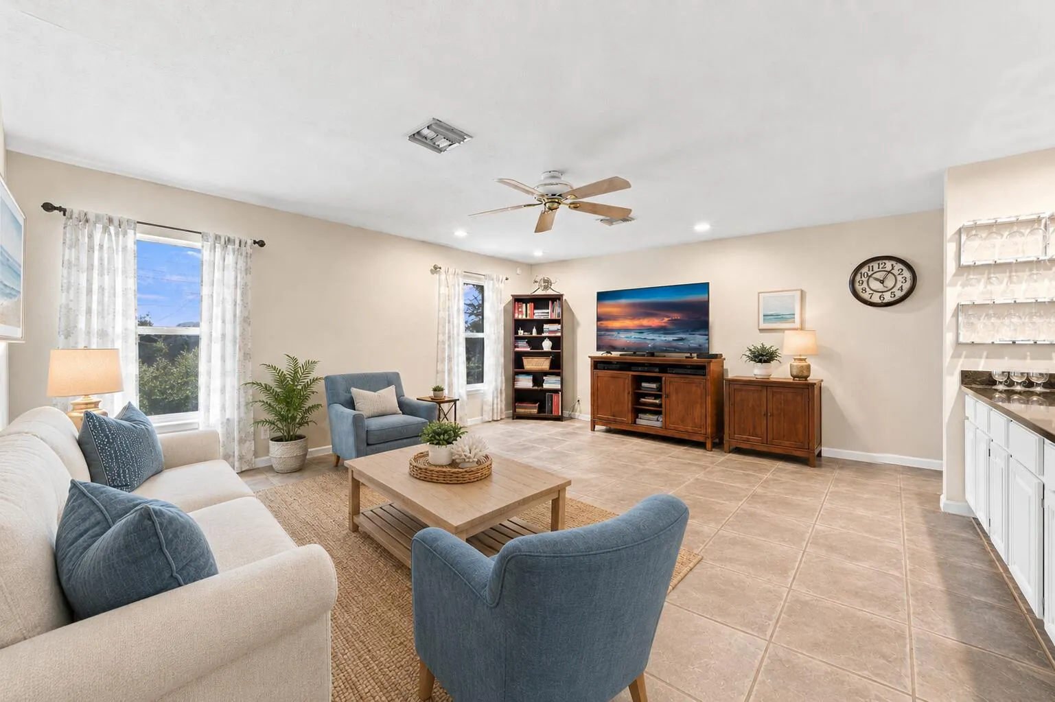 Spacious living area featuring tile flooring, recessed lighting, and a ceiling fan