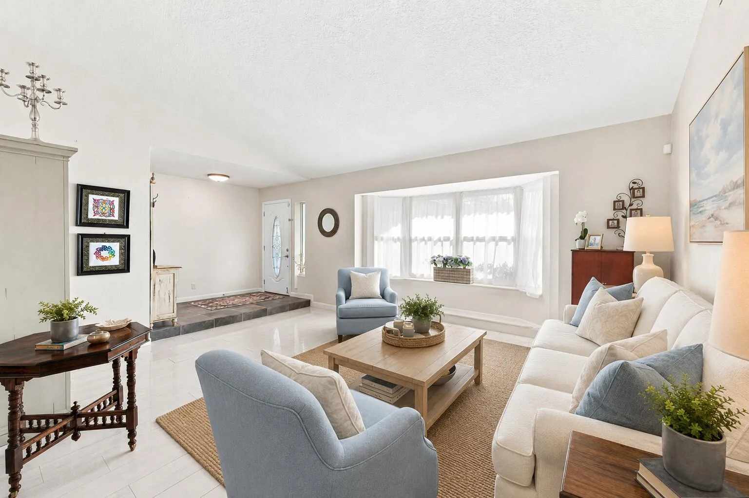 Spacious living area featuring light-toned walls and wood-finish flooring