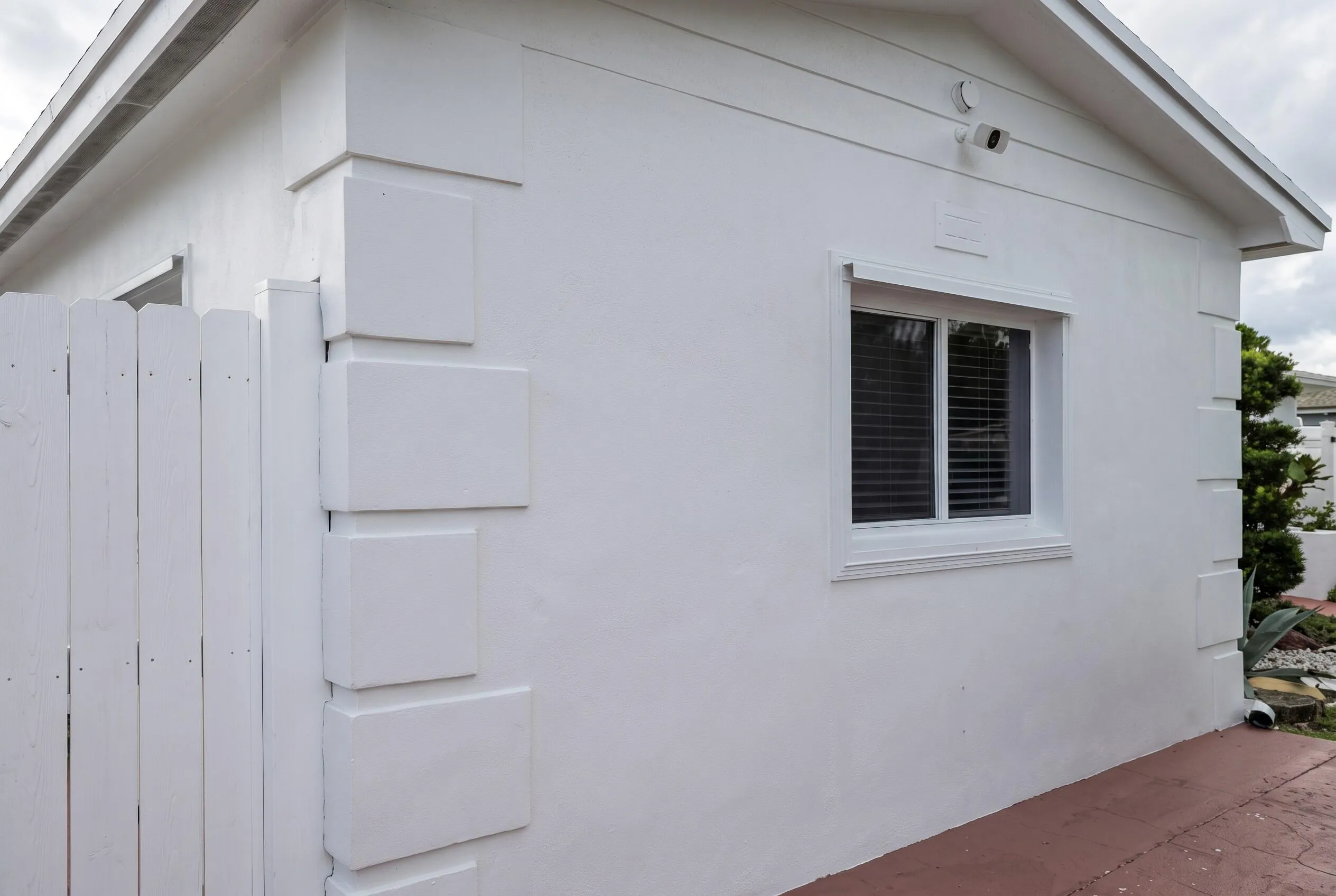 White stucco exterior with decorative corner quoining