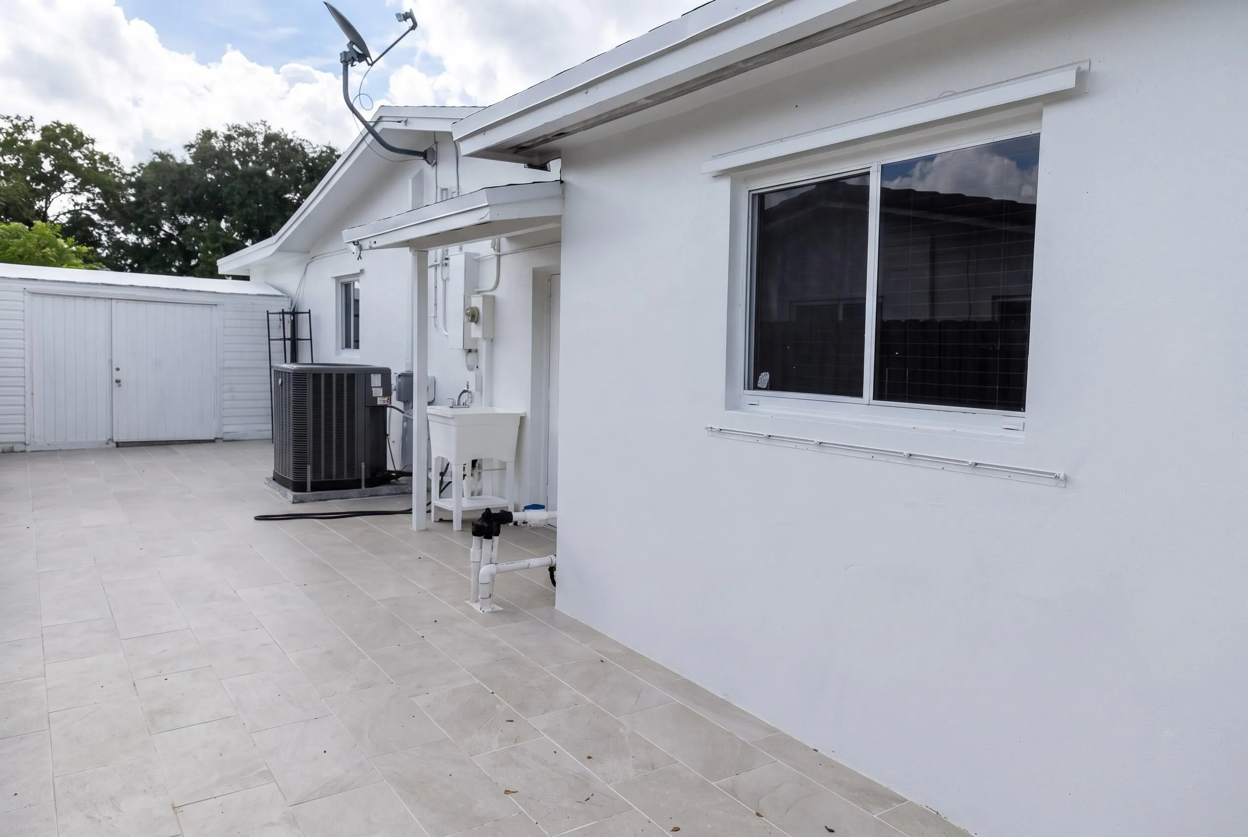 Exterior patio with light-toned rectangular tile flooring