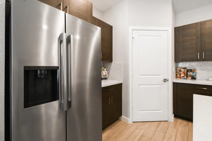 Stainless steel side-by-side refrigerator with an integrated ice and water dispenser