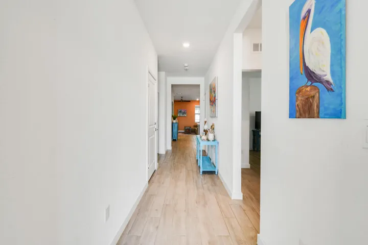 Entry Hallway featuring light-toned wood-look plank tile flooring, white walls, recessed ceiling lighting, and white trim.