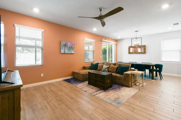 Open-concept living space featuring wood-look tile flooring, recessed lighting, and a contemporary ceiling fan