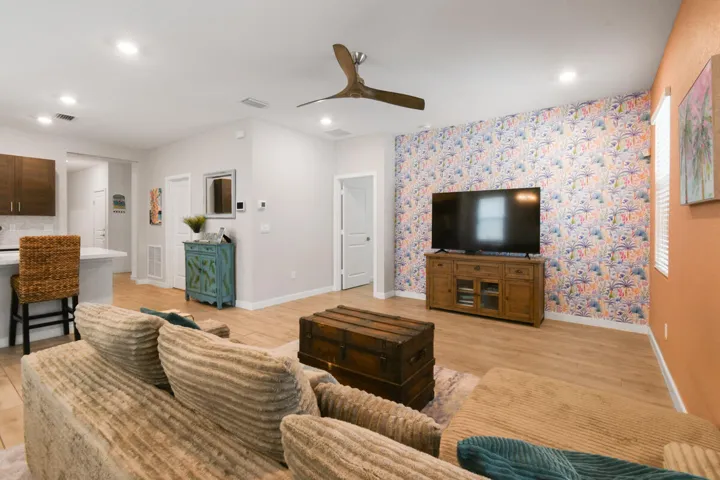 Open-concept living area featuring wood-plank tile flooring, recessed lighting, and a contemporary ceiling fan