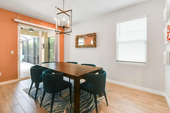 Dining area featuring wood-plank tile flooring and a contemporary chandelier