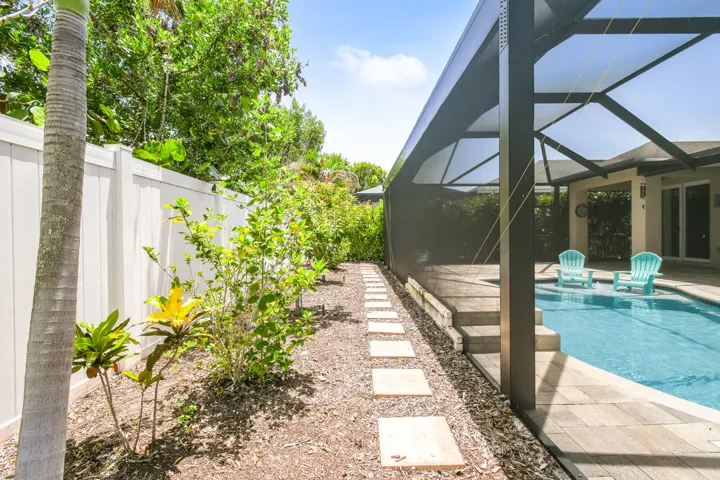 Screened pool enclosure with a stone paver deck surround keeps everything tidy.