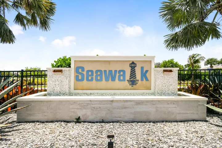 Stone monument sign with "Seawalk" lettering, lighthouse graphic, and integrated water feature