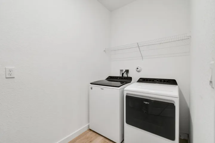 Dedicated laundry area featuring a white wire shelving and wood-plank tile flooring