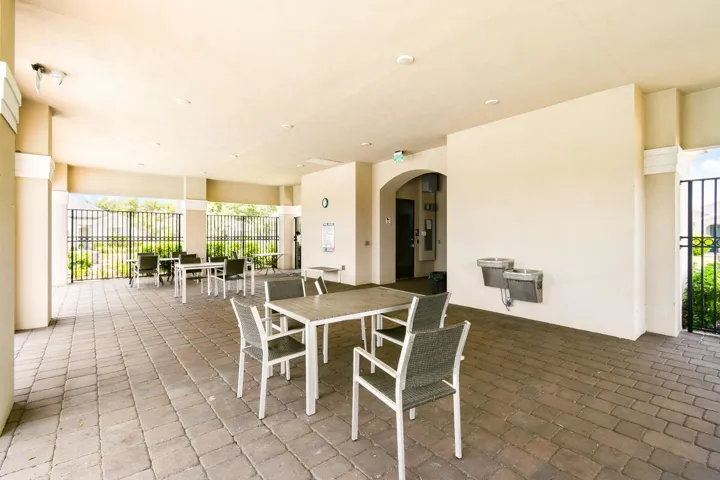 Covered patio area featuring paver flooring and multiple seating arrangements