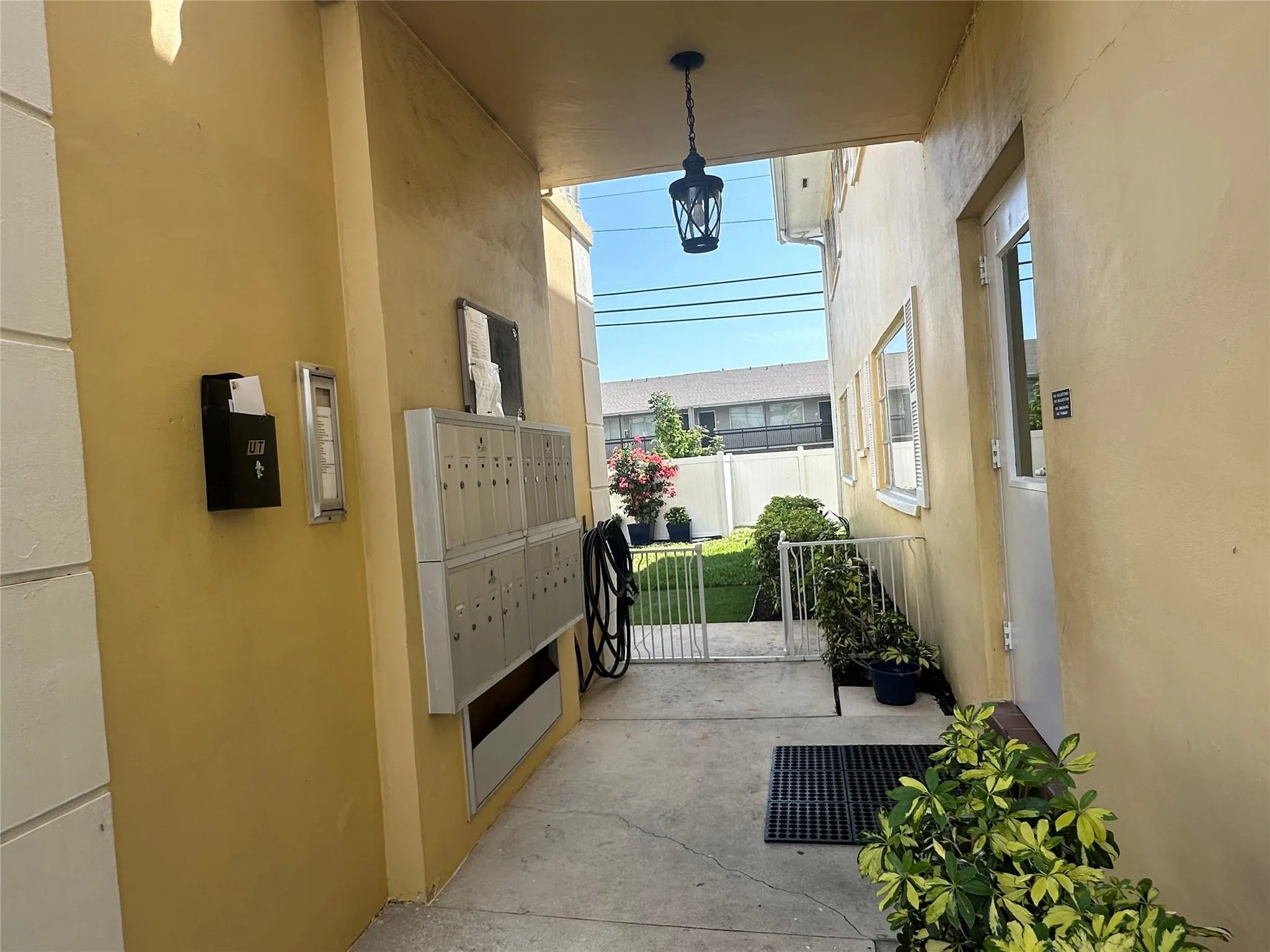 Covered entryway with overhead lighting, a wall-mounted mailbox system, and an exterior door with frosted glass panels