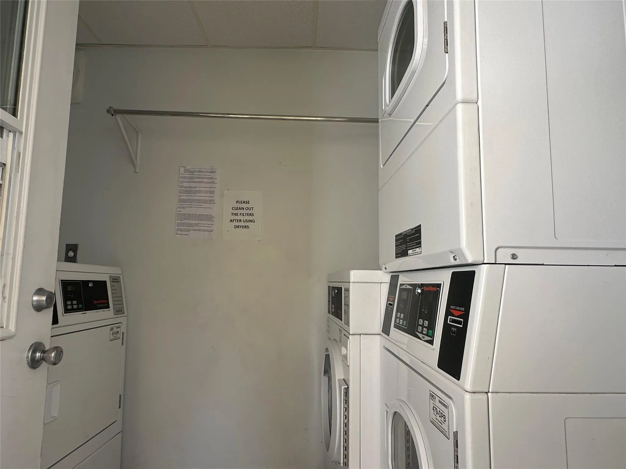 Dedicated laundry area featuring multiple stacked washer and dryer units