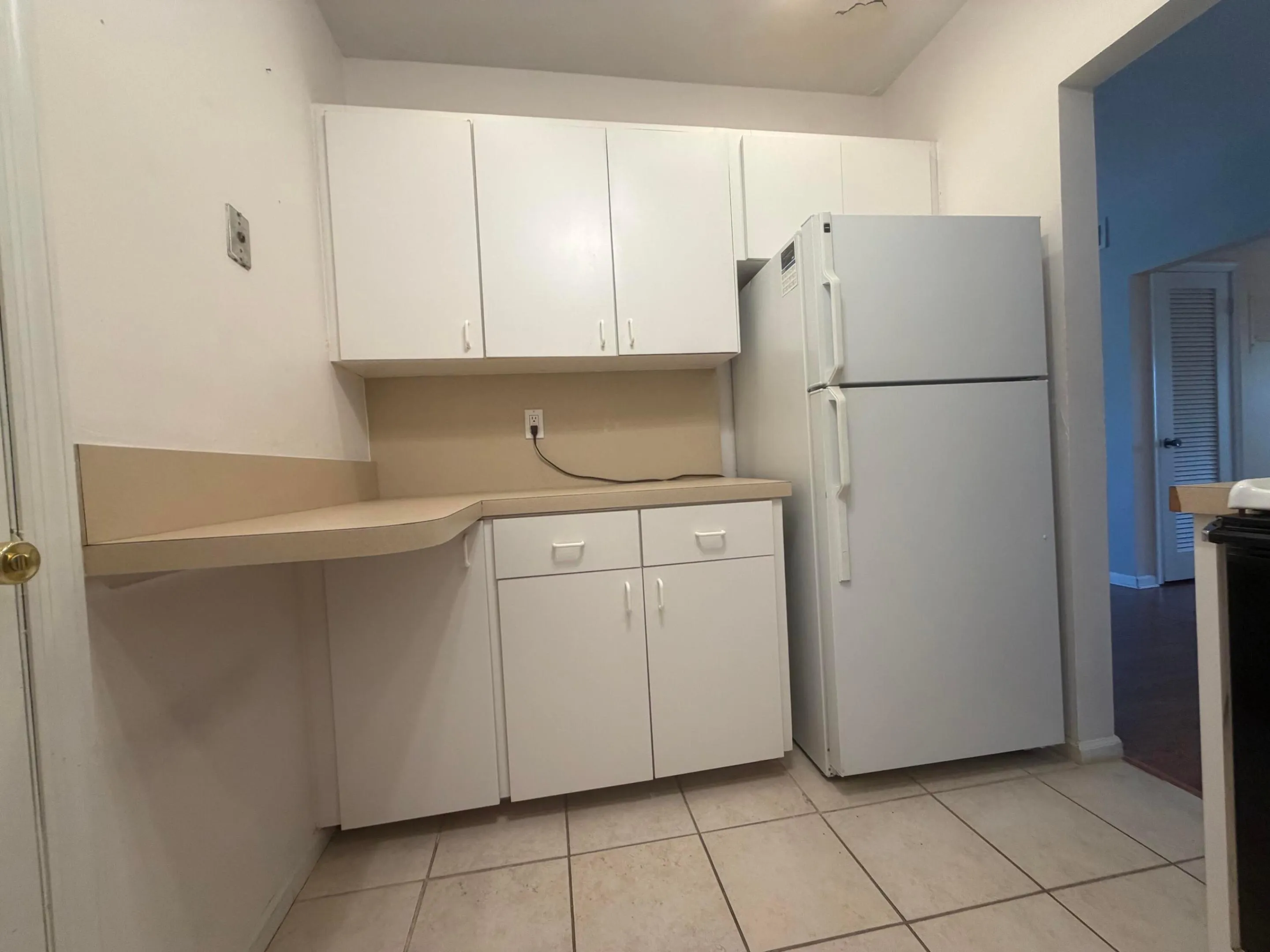 White cabinets with a breakfast nook and white regrigerator.