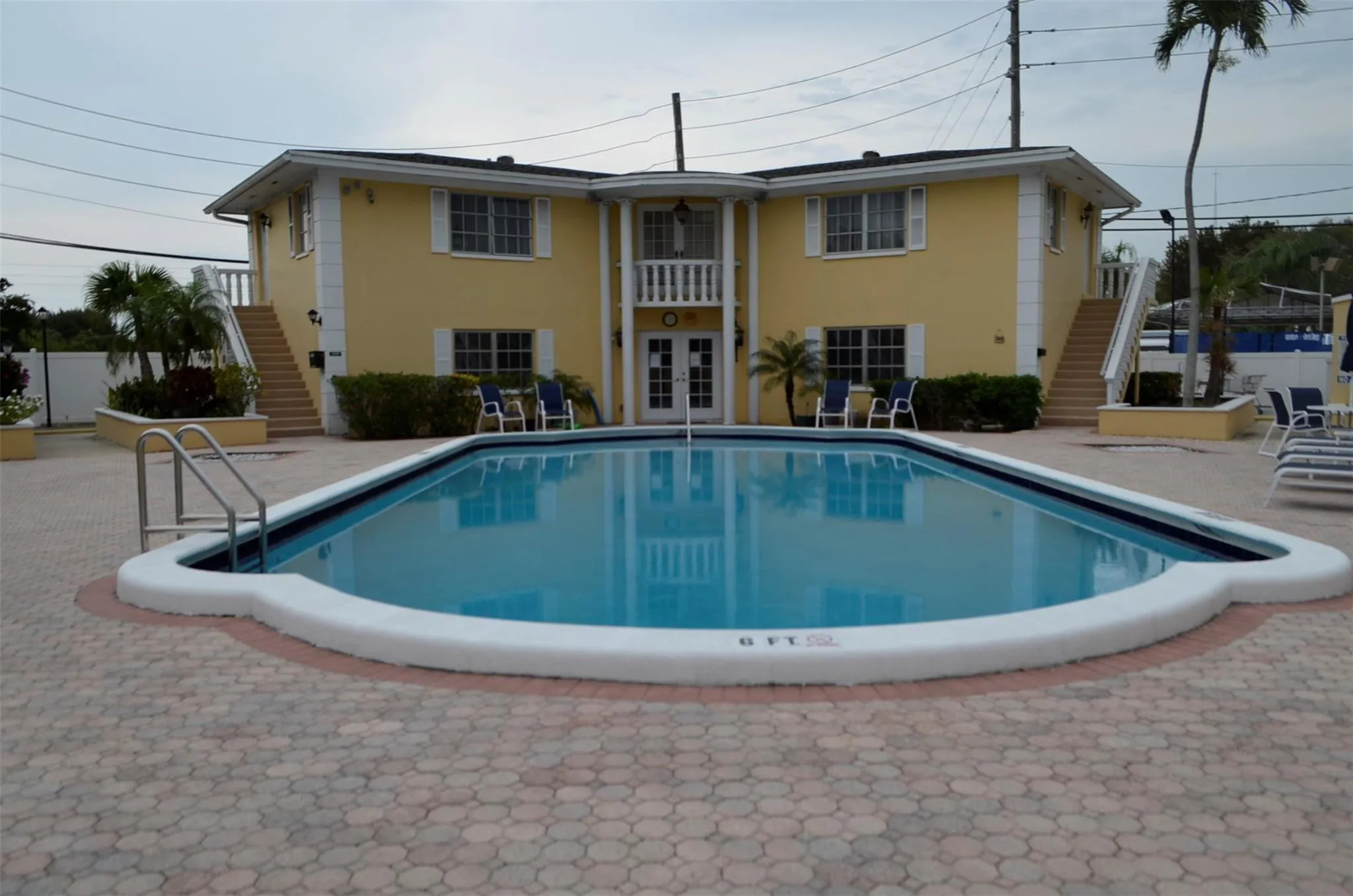 Resort-style outdoor pool with a curvilinear design and integrated steps, surrounded by a paver deck